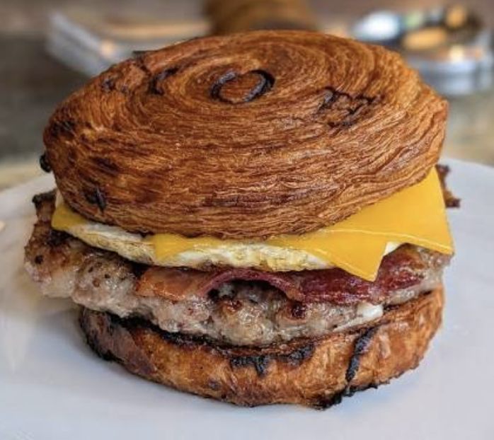 Croissant breakfast sandwich with sausage, egg, and melted cheese